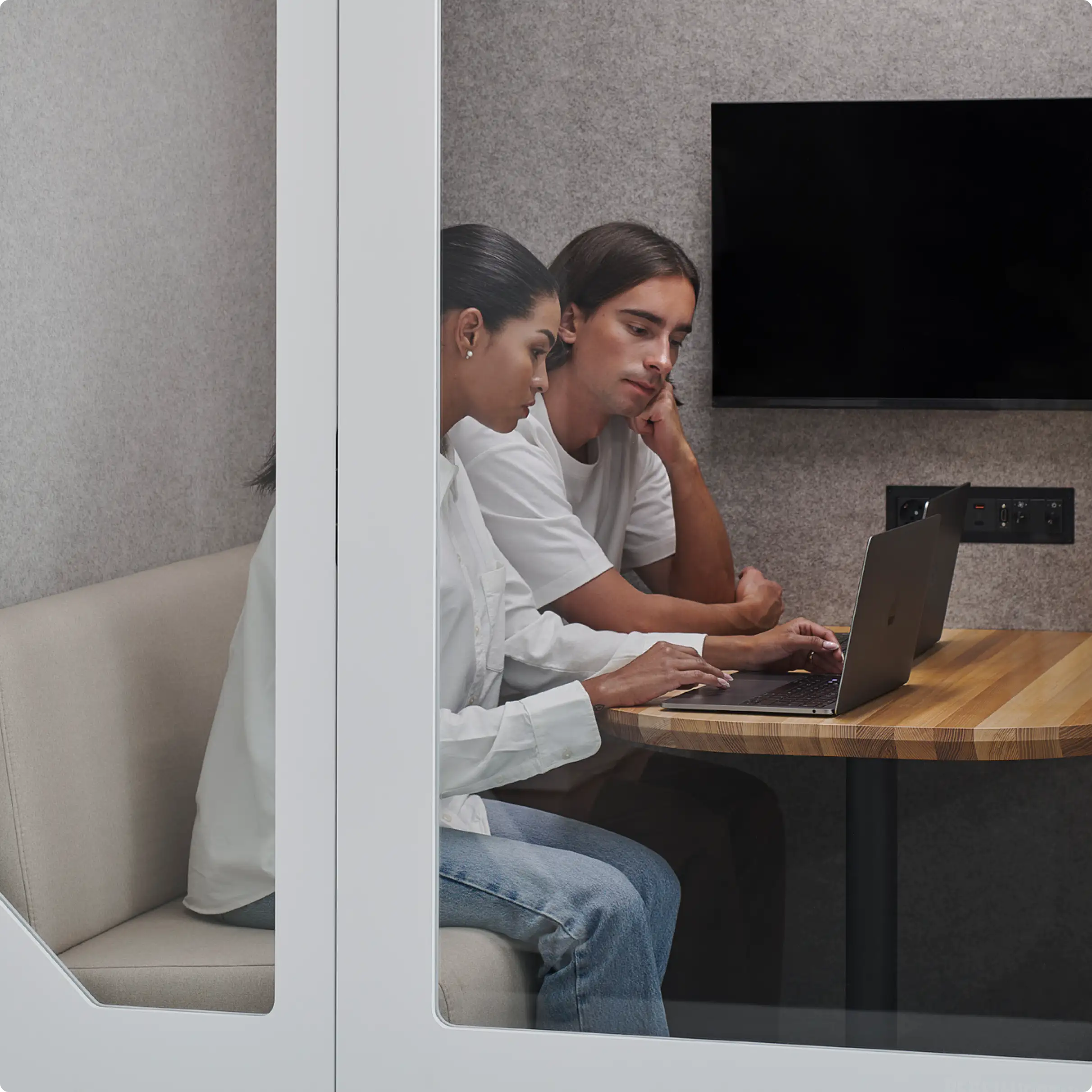 Two people working next to each other inside of Persy Four office booth