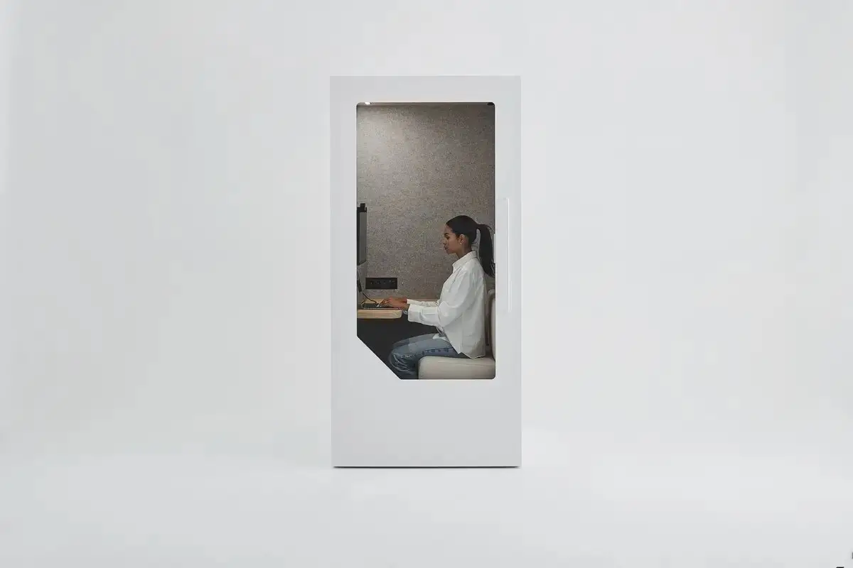 Person working comfortably inside a soundproof office pod at a desk
