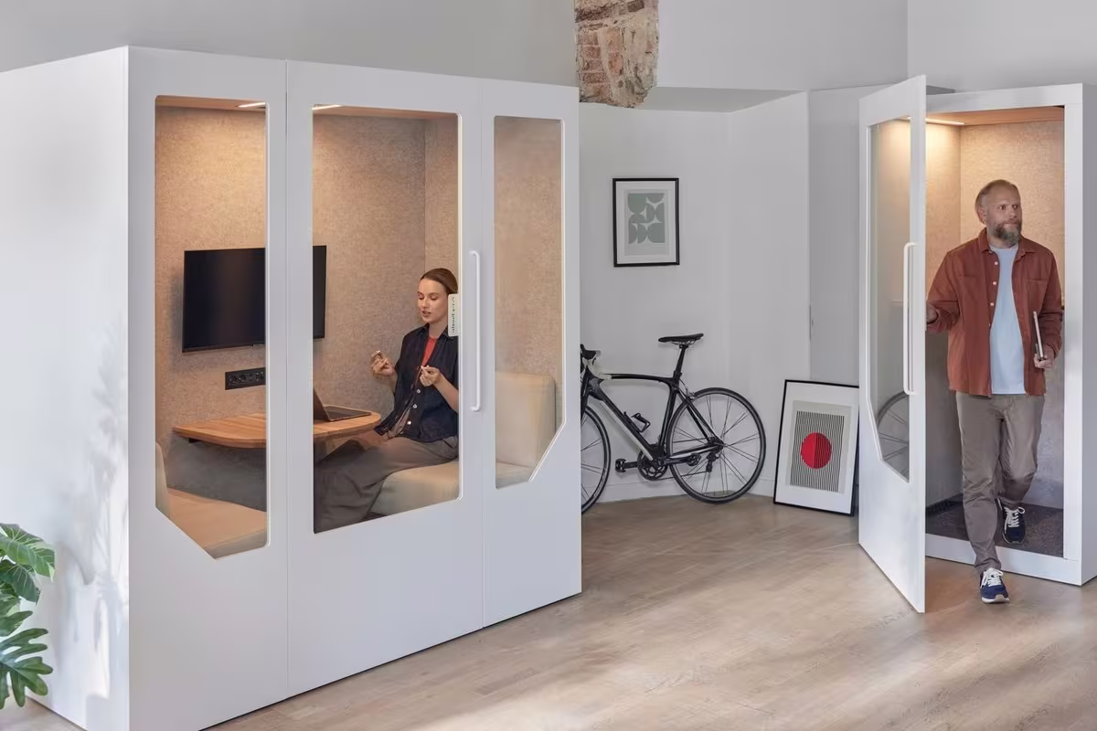Two people using soundproof office pods for focused work and private calls