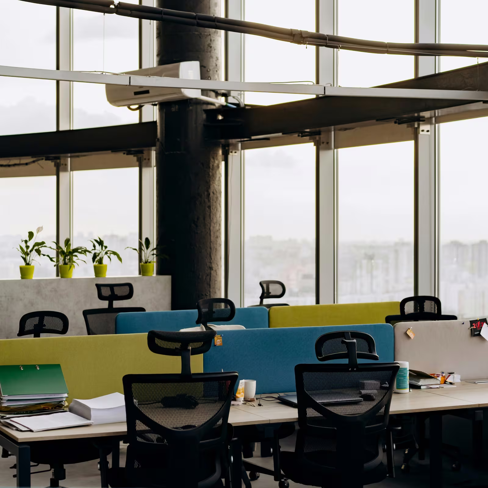 Open plan office with acoustic desk dividers and large windows