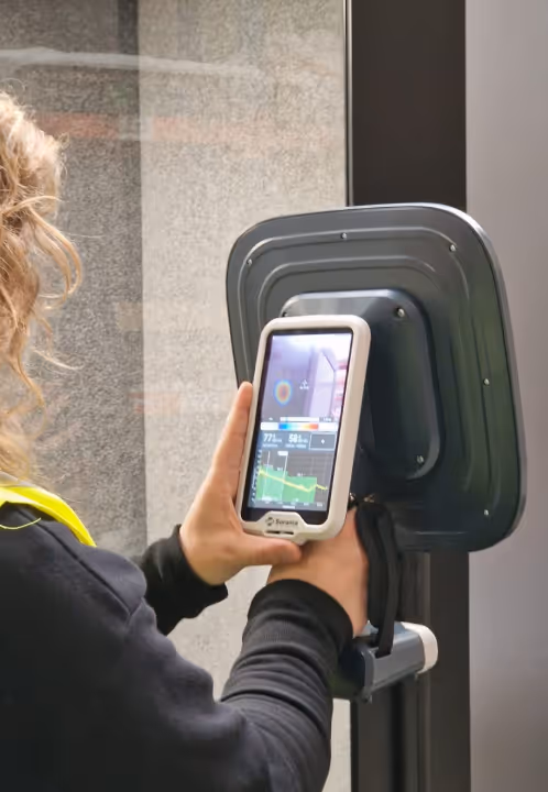 Installer checking Persy Booth setup with a handheld diagnostic tool