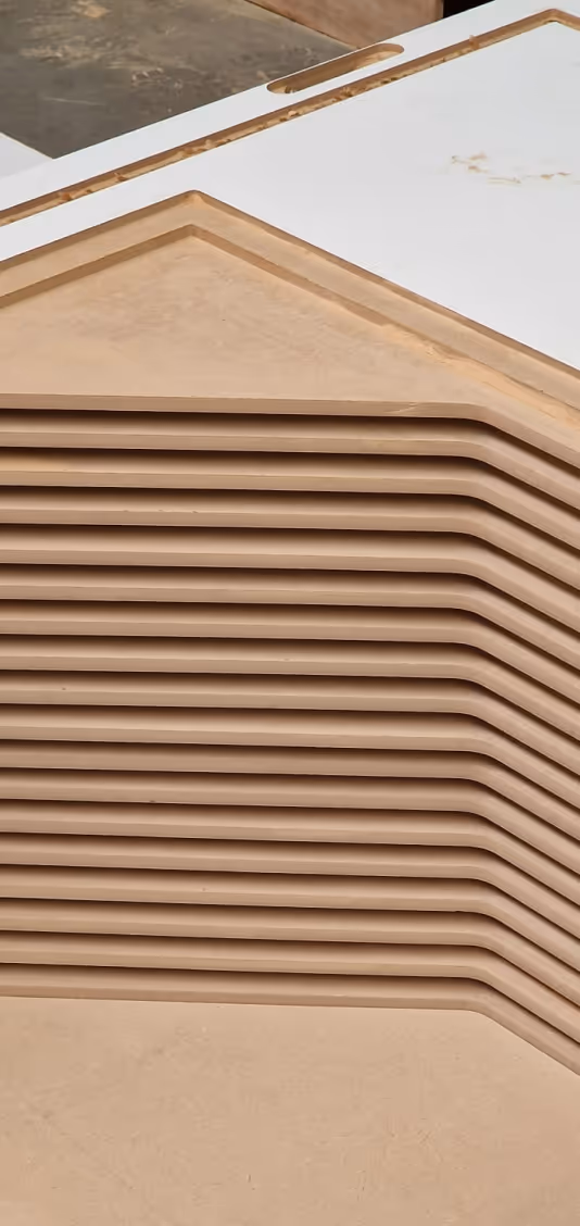 Stacked eco-friendly wood panels prepared for manufacturing Persy office booths.