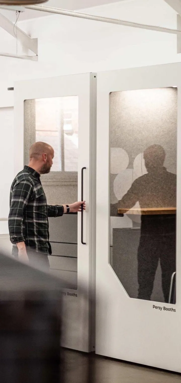Employee assembling a Persy soundproof booth designed with sustainable materials for modern offices