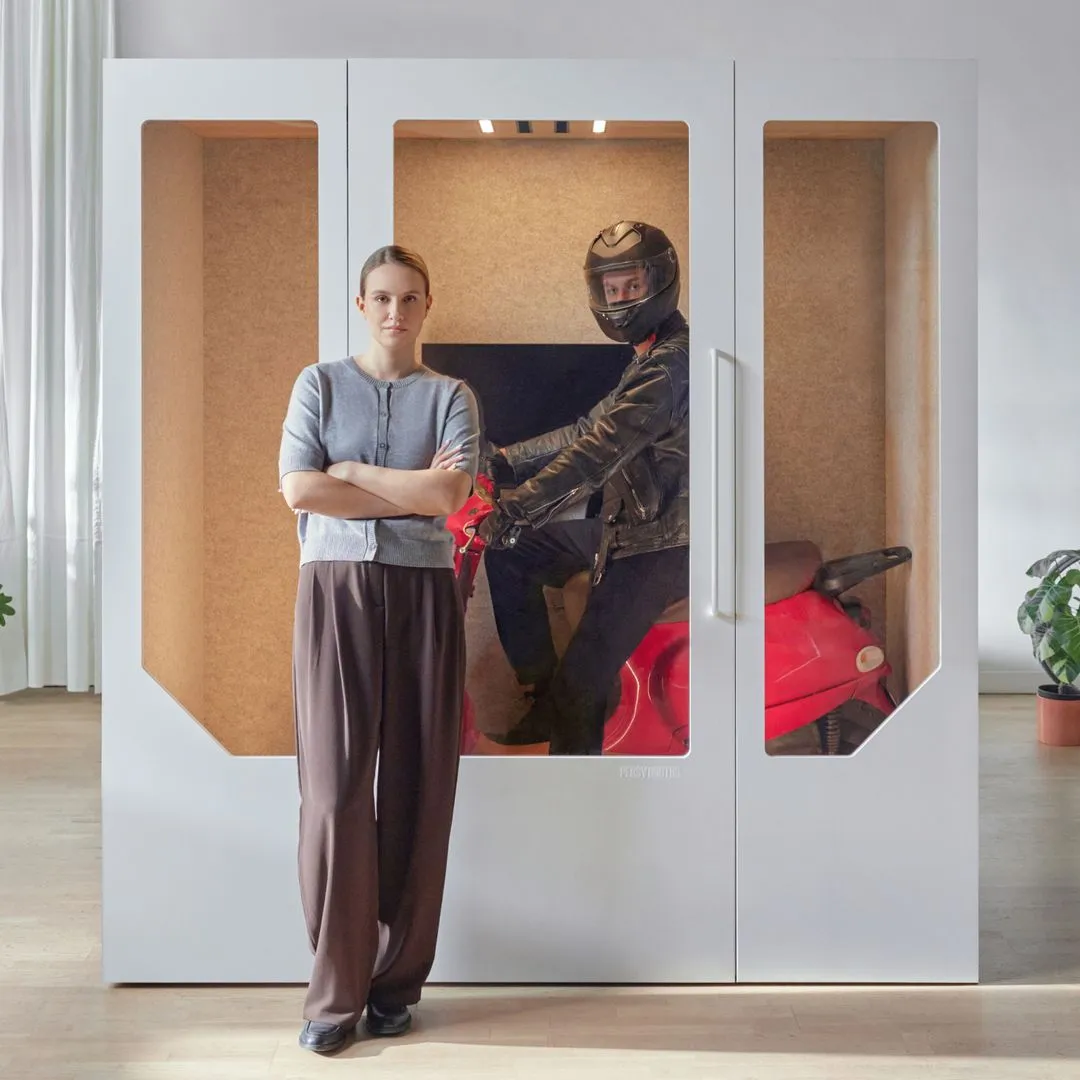 Modern soundproof office booth by Persy Booths featuring a woman standing confidently beside a private workspace, with a man on a red motorcycle inside showcasing the booth’s superior noise isolation and sleek design for home and office use.