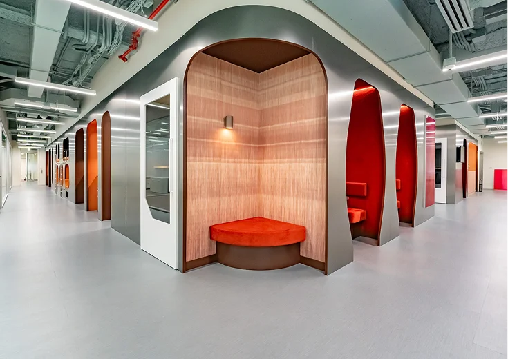 Persy Booths team standing in front of a bright yellow soundproof office pod