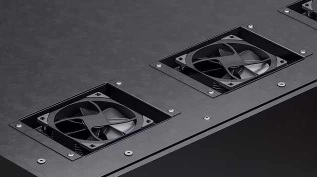 Close-up of black cooling fans mounted on a dark metal surface with visible screws.