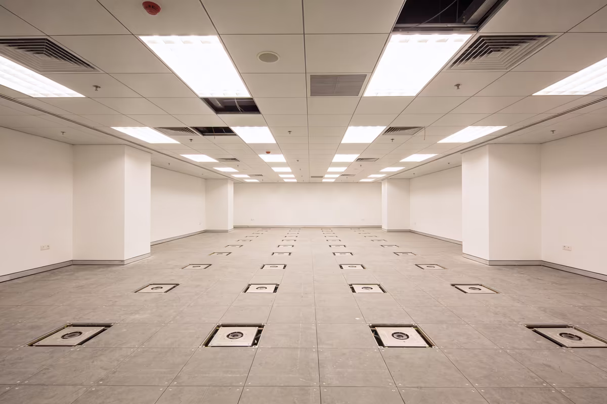 Empty commercial office space with raised flooring and basic infrastructure before fit out