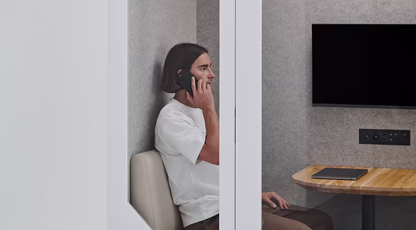 Customer support agent on a phone call inside a quiet Persy soundproof booth