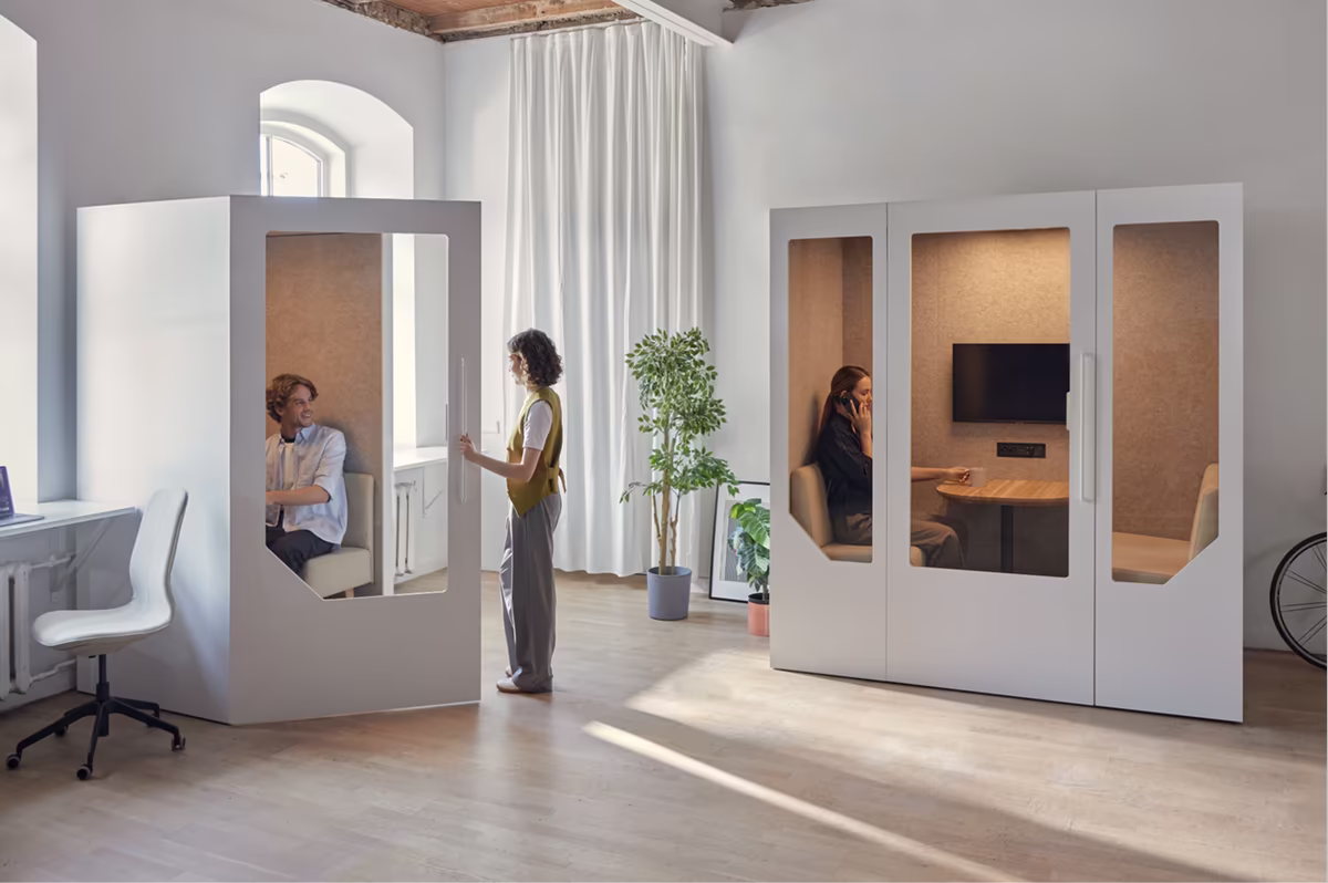 Person using a soundproof office booth for private phone calls