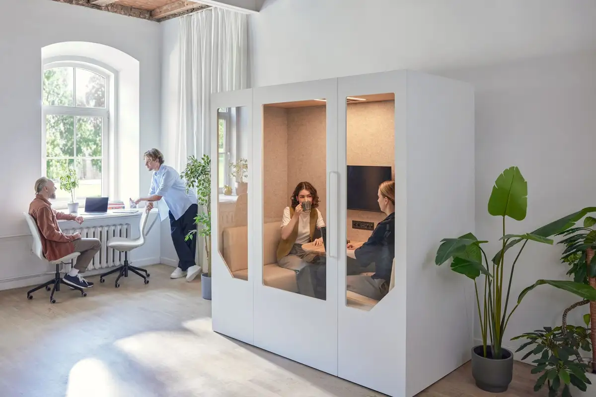 two people in a meeting pod having a discussion in an open plan office