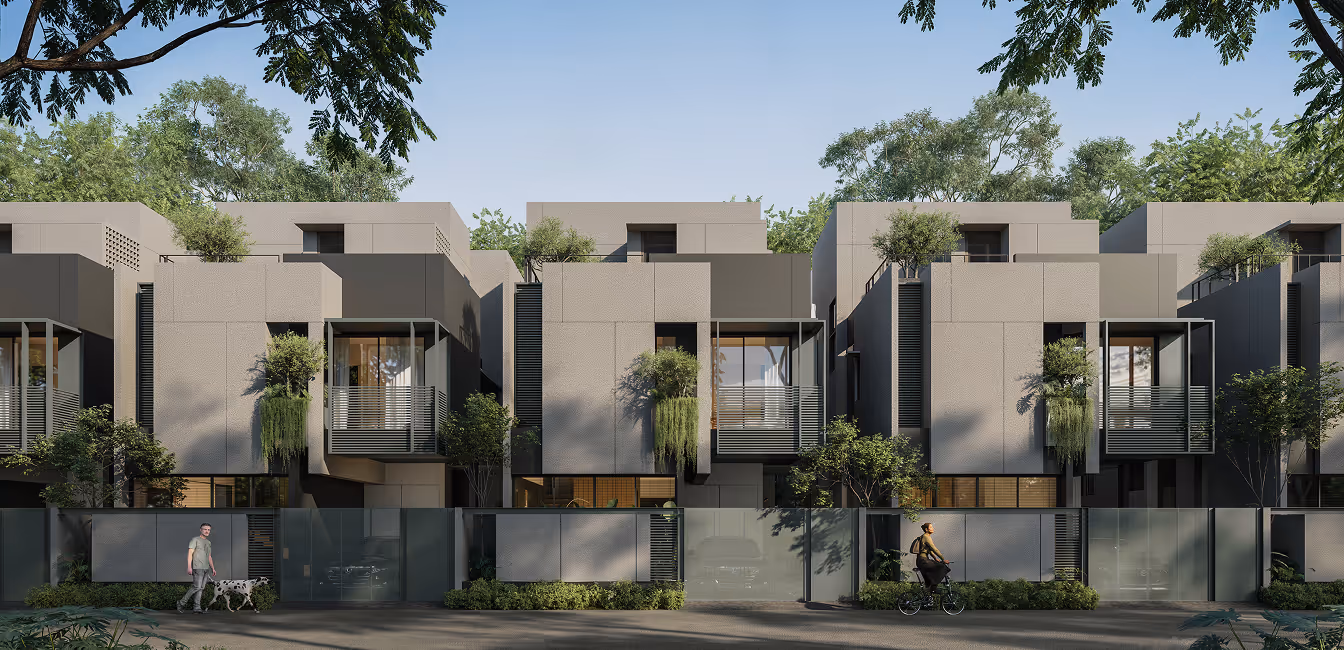 Modern row of multi-story houses with balconies, greenery, and people walking and cycling in front.