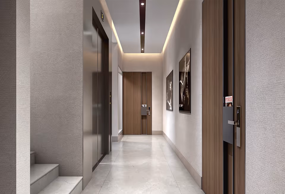 Modern hallway with wood doors, elevator, marble floor, and black-and-white framed photos on the wall.