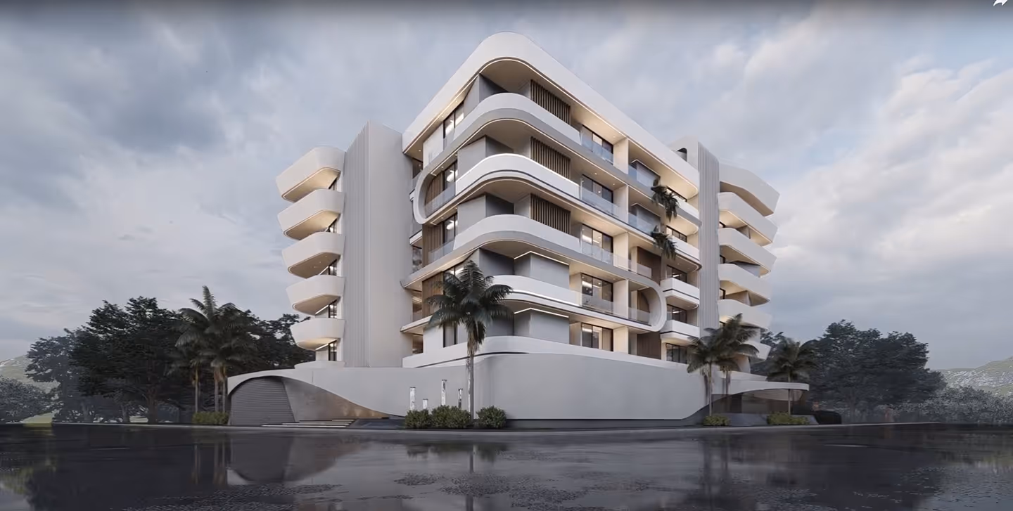Modern multi-story building with curved balconies and palm trees against cloudy sky.