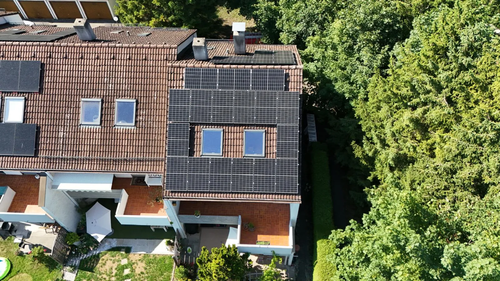 Luftaufnahme von Solarmodulen auf einem Wohnhausdach, die Sonnenlicht in Strom umwandeln