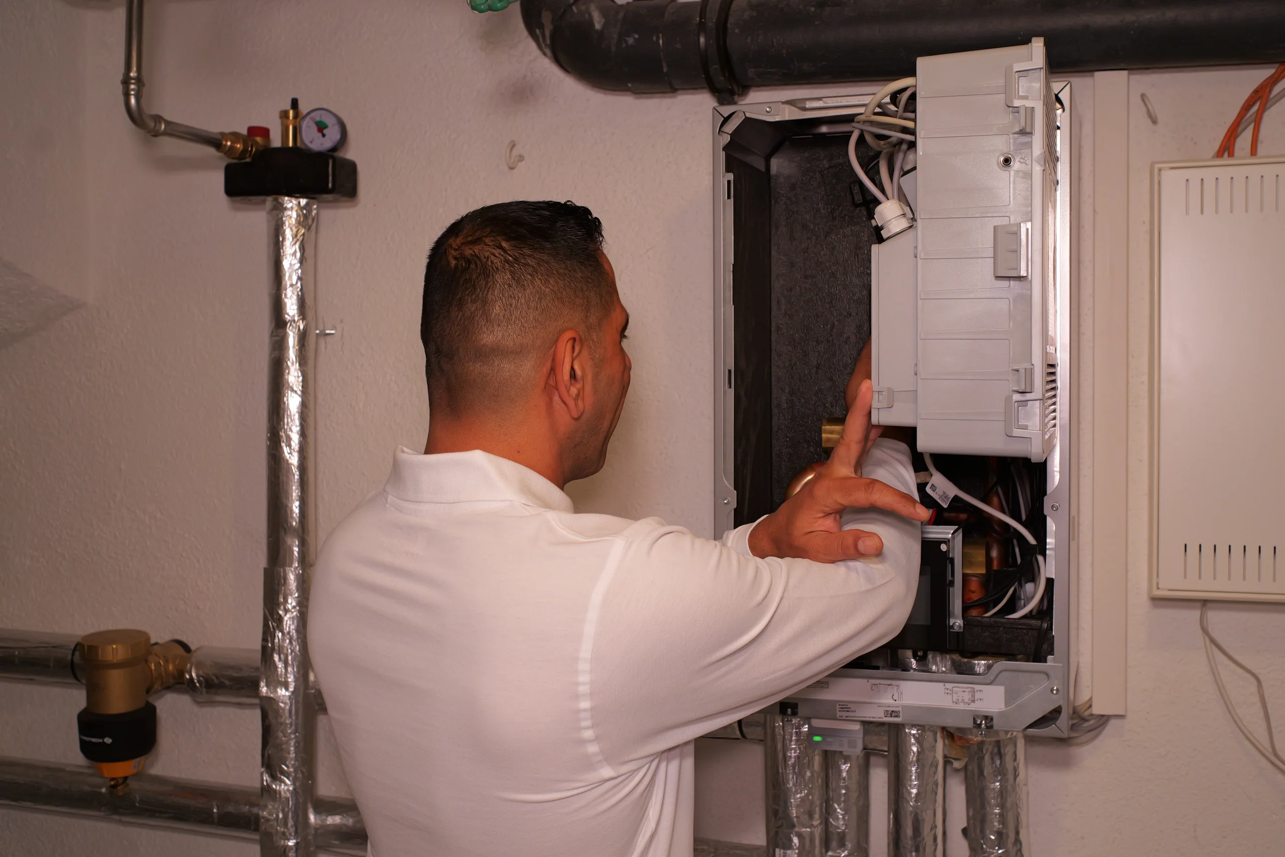 Techniker der ThermaWerk GmbH montiert die Inneneinheit der Wärmepumpe im Heizungskeller
