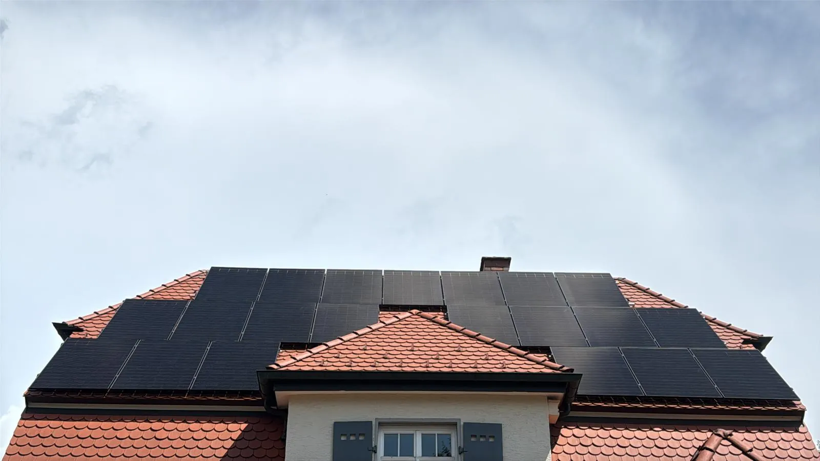 Photovoltaikanlage mit schwarzen Modulen auf dem Ziegeldach eines Wohnhauses in Erding