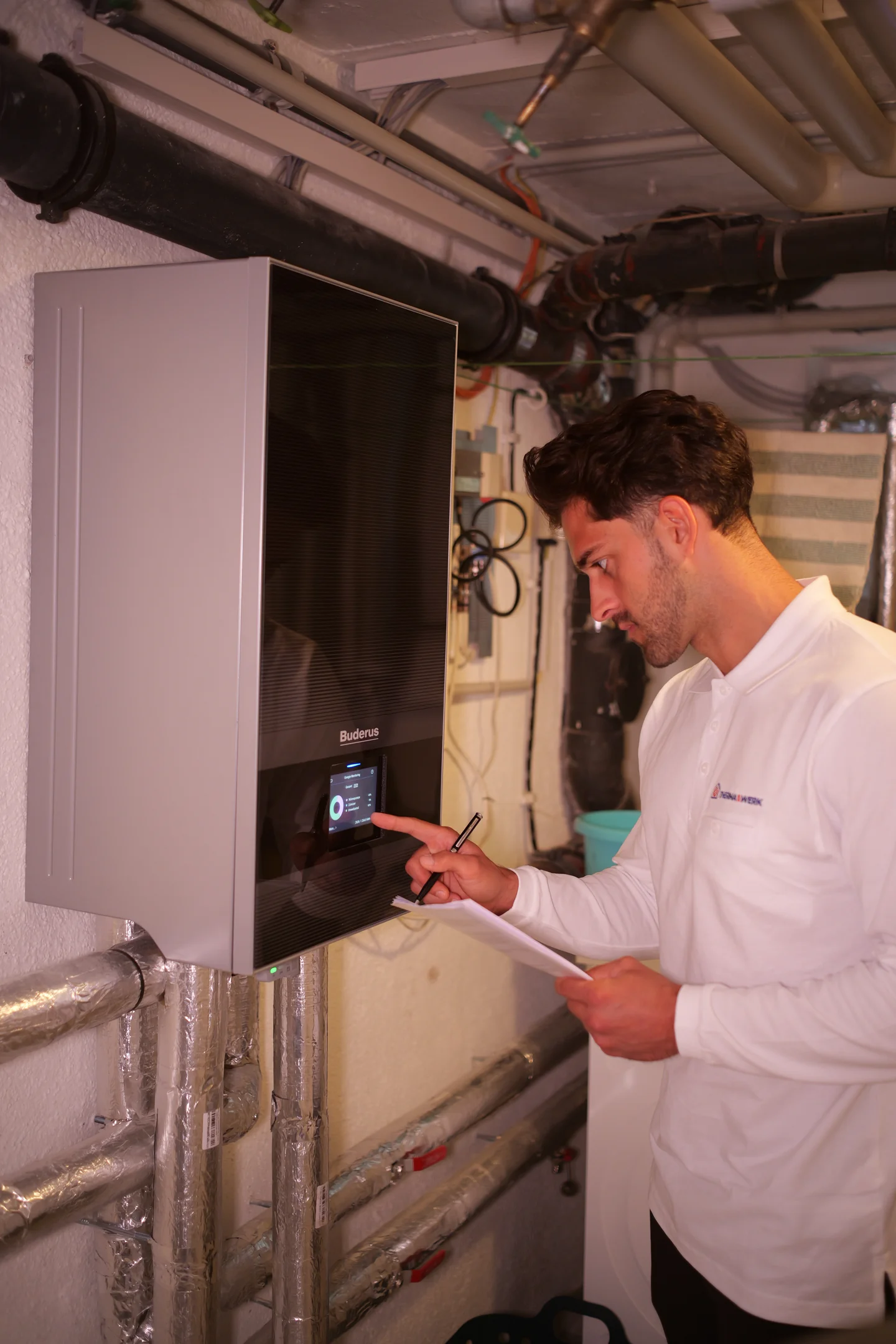 Techniker der ThermaWerk GmbH bedient das Display einer Wärmepumpe