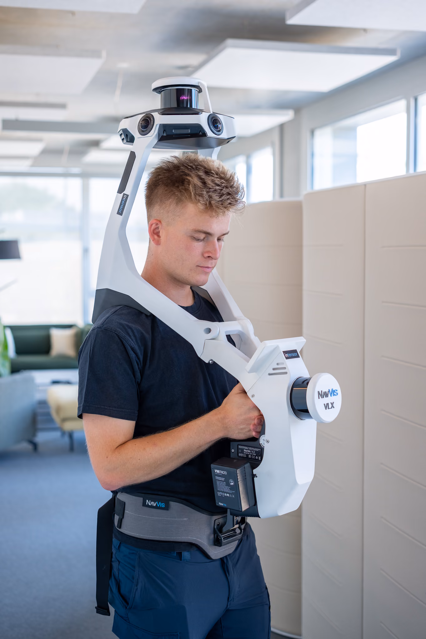 Junger Mann benutzt tragbares NavVis VLX 3D-Scan-Gerät in einem modernen Büro.