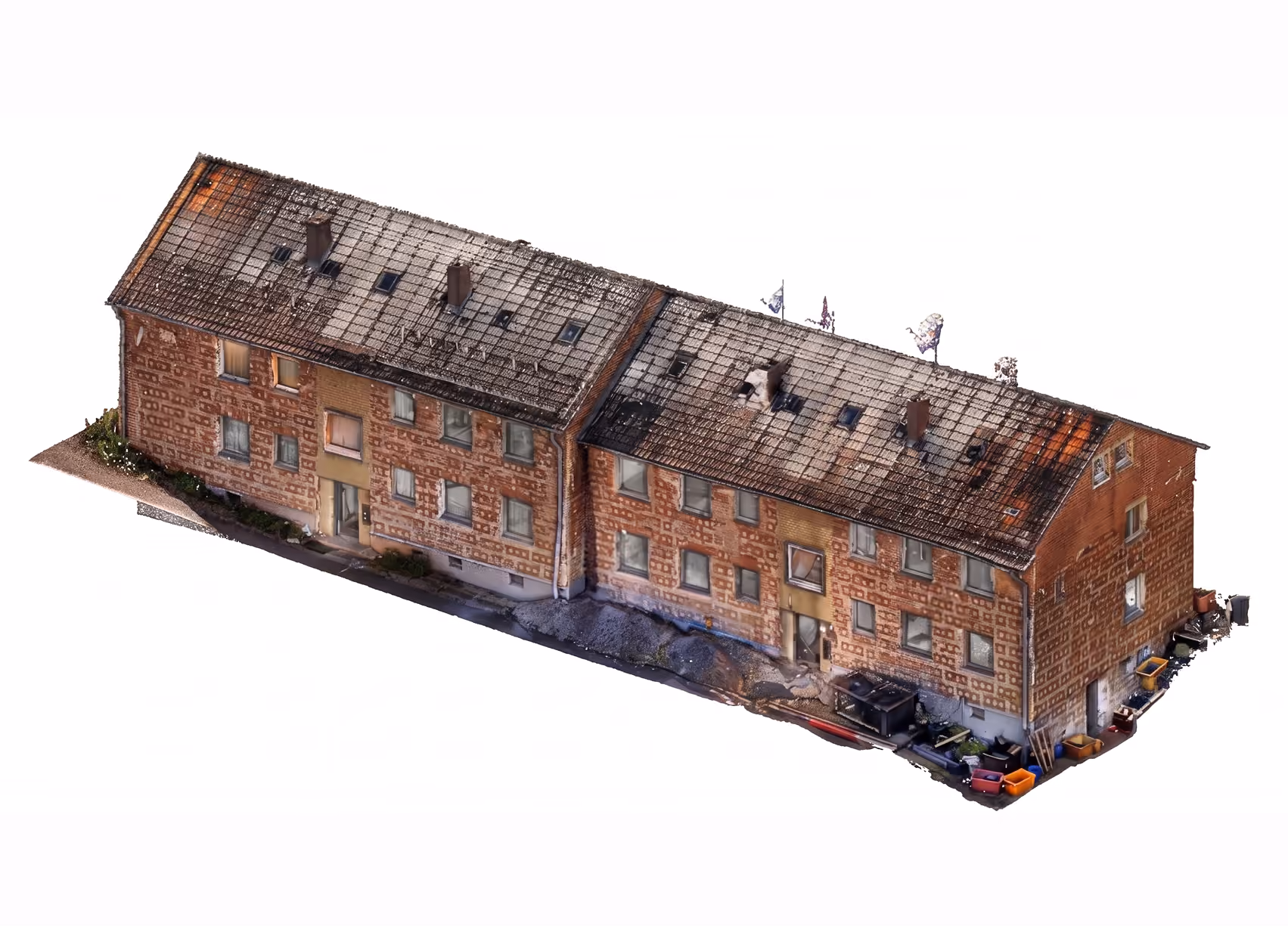 Modell eines länglichen zweistöckigen Wohngebäudes mit ziegelroter Fassade und mehreren Fenstern sowie zwei Eingängen, mit einem leicht beschädigten, schrägen Dach.