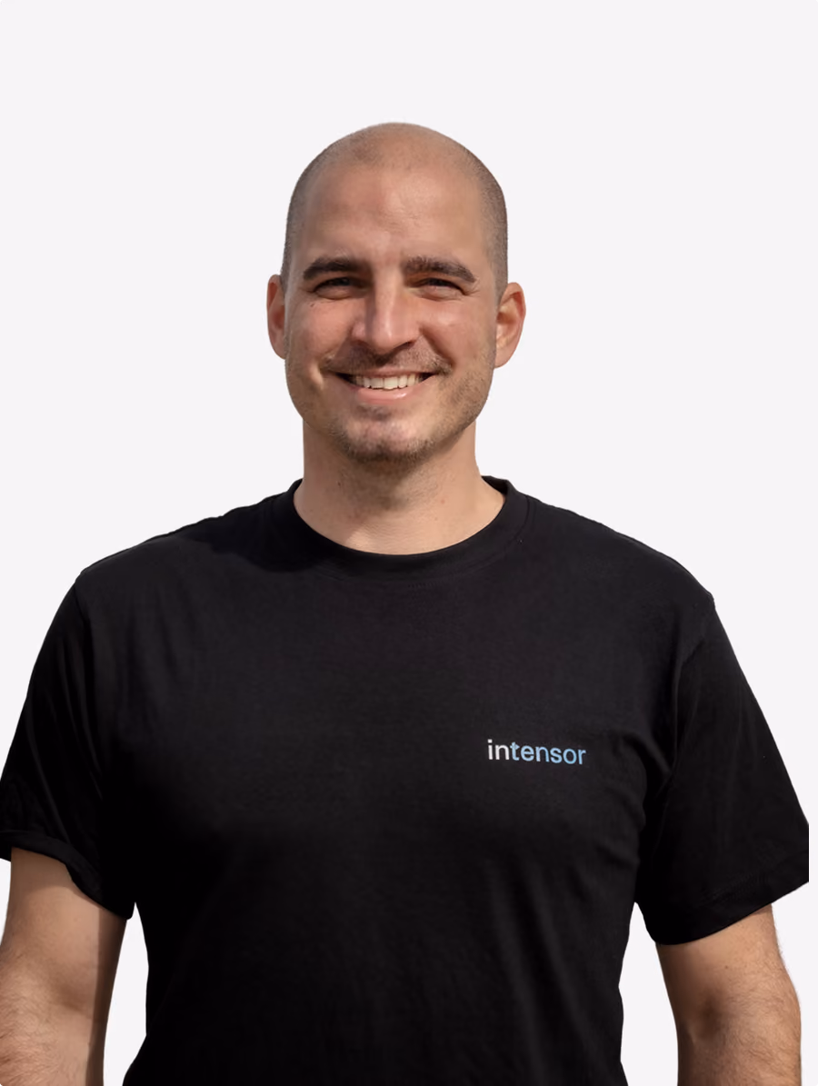 Junger Mann mit Bart und T-Shirt mit 'intensor' Logo vor weißem Hintergrund.