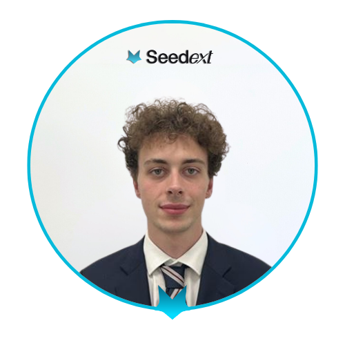 Portrait d'un jeune homme aux cheveux bouclés portant un costume noir, une chemise blanche et une cravate rayée, avec le logo Seedext en arrière-plan.