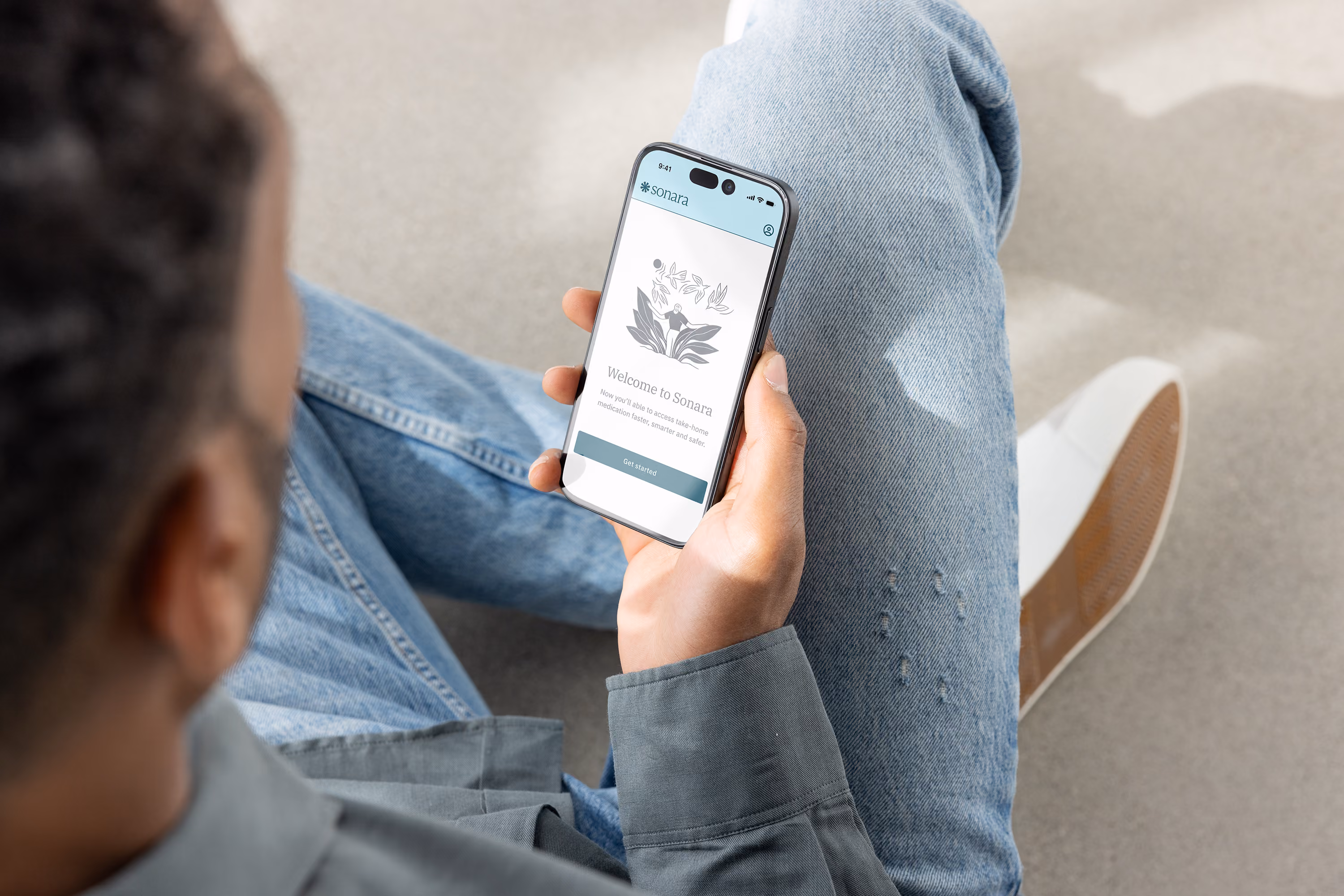 Person holding a smartphone displaying Sonara app welcome screen with a 'Get started' button.