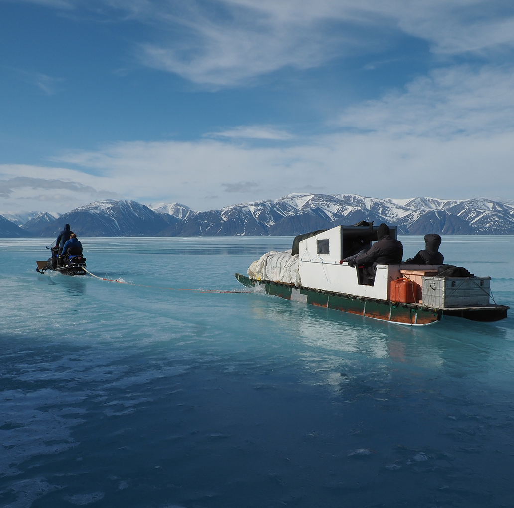 a sled pulling a load of supplies overtop a frozen lake