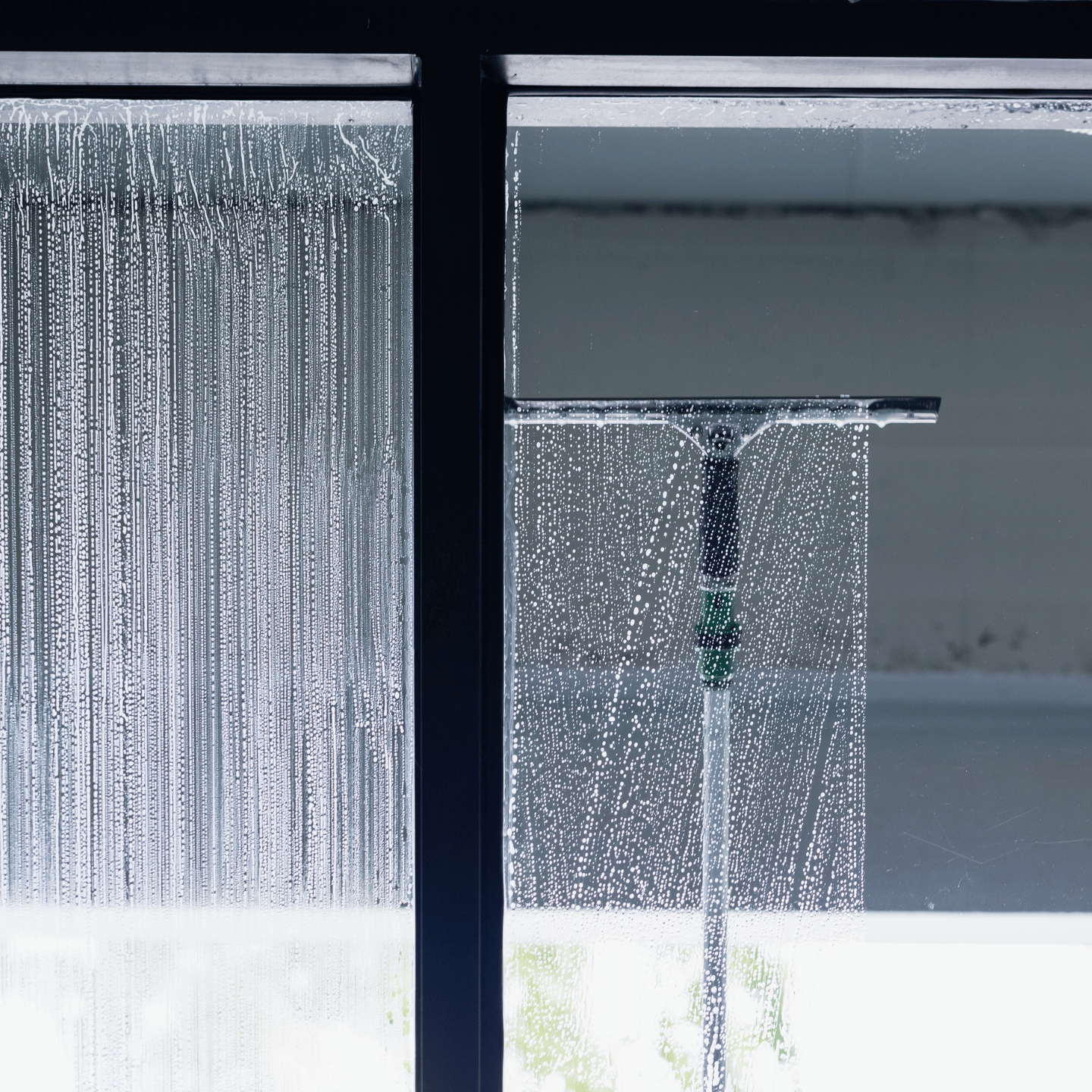 Glasreinigung: Glasscheibe wird mit einem Abzieher gereinigt