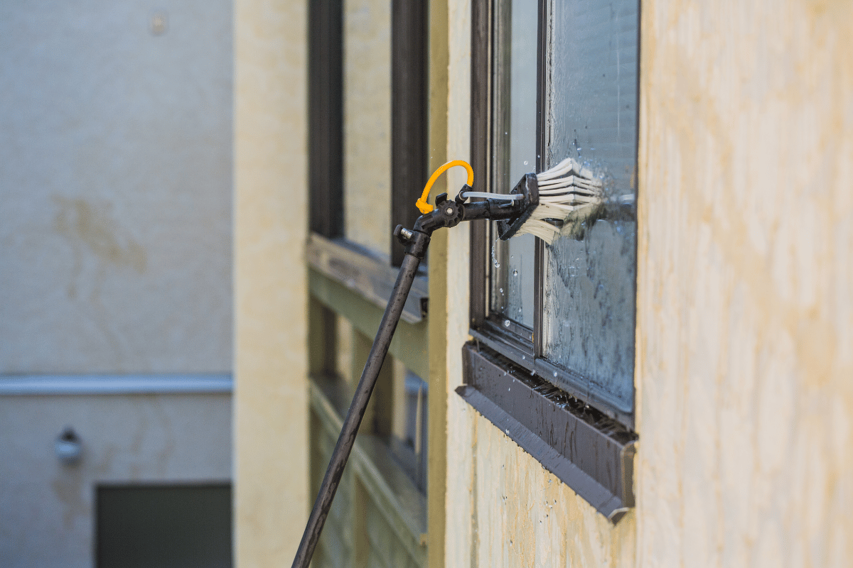 Fenster wird von außen mit einer Teleskopstange gereinigt