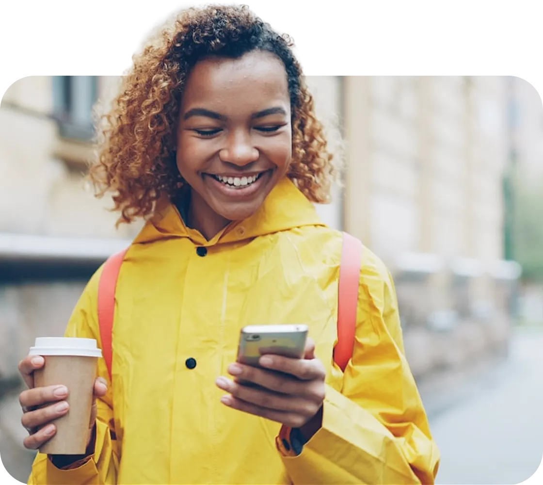 Woman in a yellow raincoat using her phone