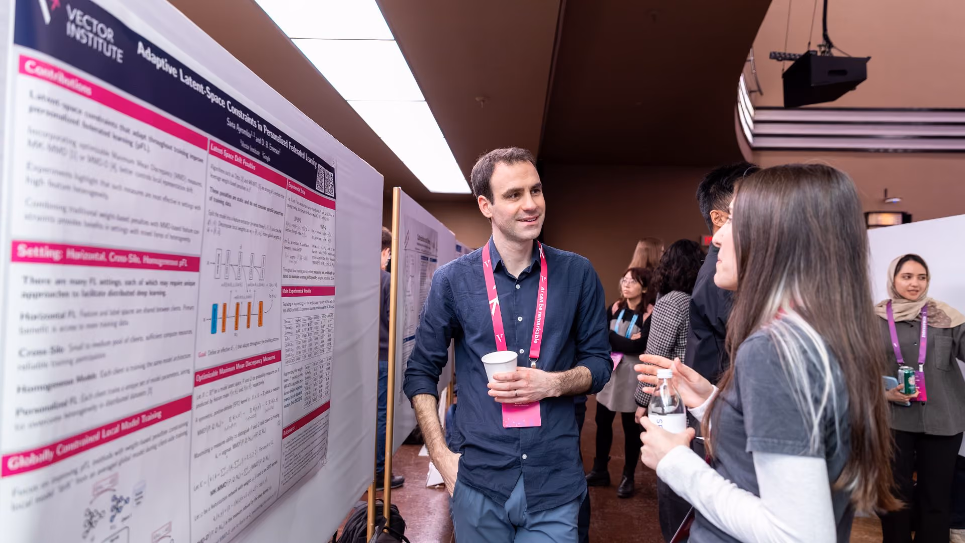 A researcher discusses their poster titled "Adaptive Latent-Space Constraints in Personalized Federated Learning" with an attendee at a Vector Institute poster session. A Vector Institute banner is visible in the background.
