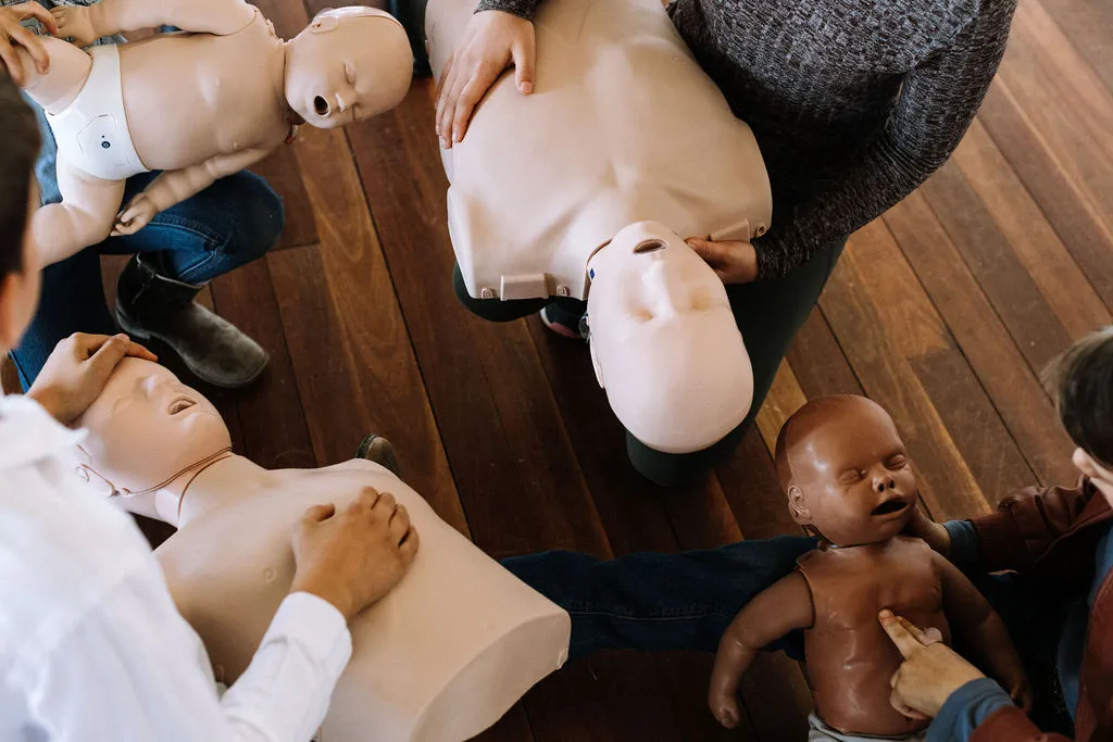 Participants practising infant CPR on manikins during a PAEDS paediatric first aid course