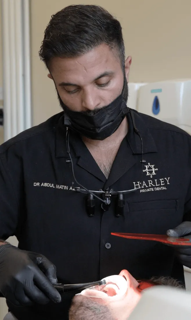Dr Ehsan Naghieh of Harley Private smiling with a camera