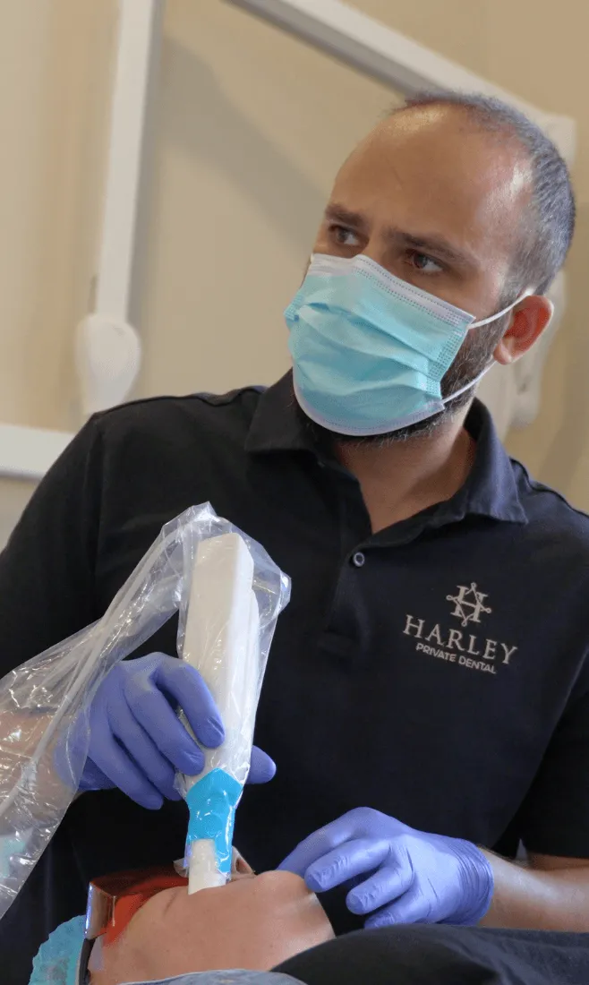 Harley Private dentist chatting with a smiling patient in the dental chair