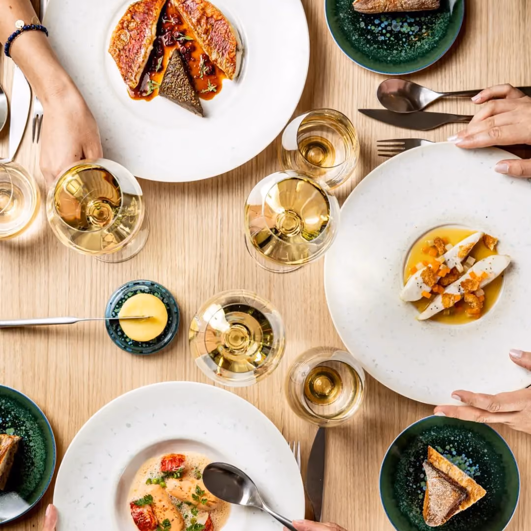 Table du comptoir Pavyllon Lyon, plats et verres de vin blanc