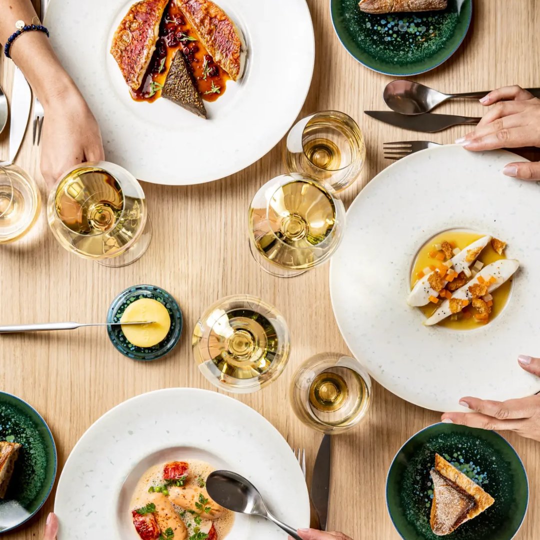 Table du comptoir Pavyllon Lyon, plats et verres de vin blanc