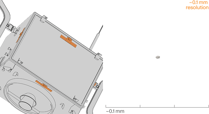 Microscopic view of a tiny irregular object with ~0.1 mm scale bars on a black background.