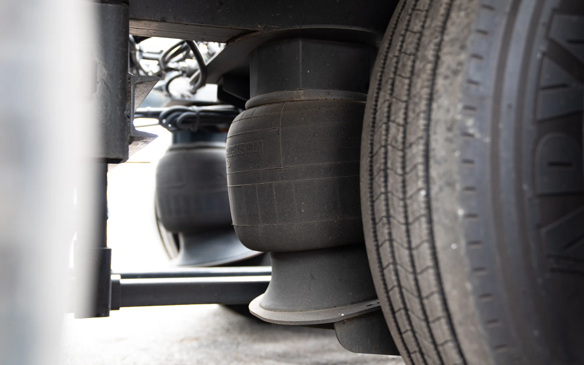 Close-up of air suspension components and tire on a heavy vehicle.
