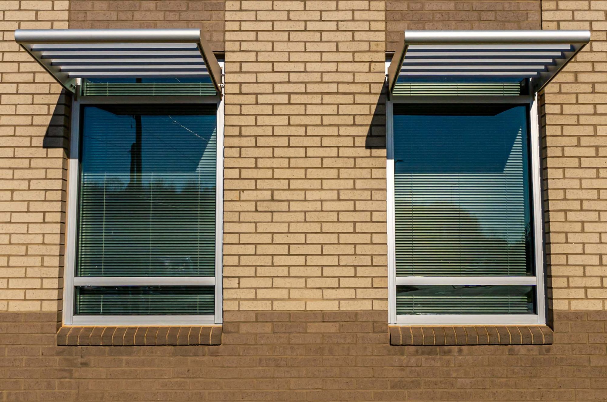 Punched windows with sunshades on the brick elevation