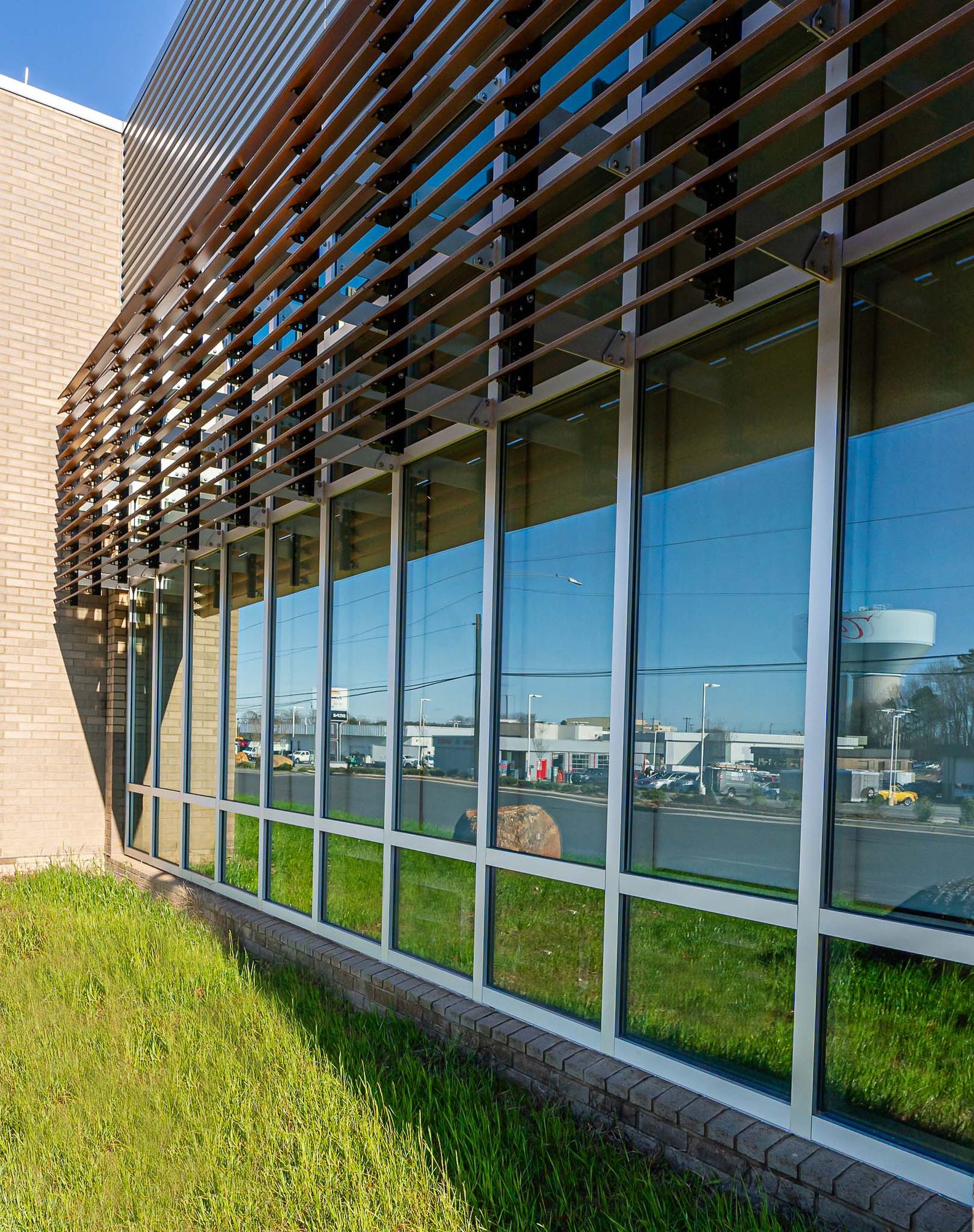 Curtainwall corner beneath a wood sunscreen at Cabarrus County EMS