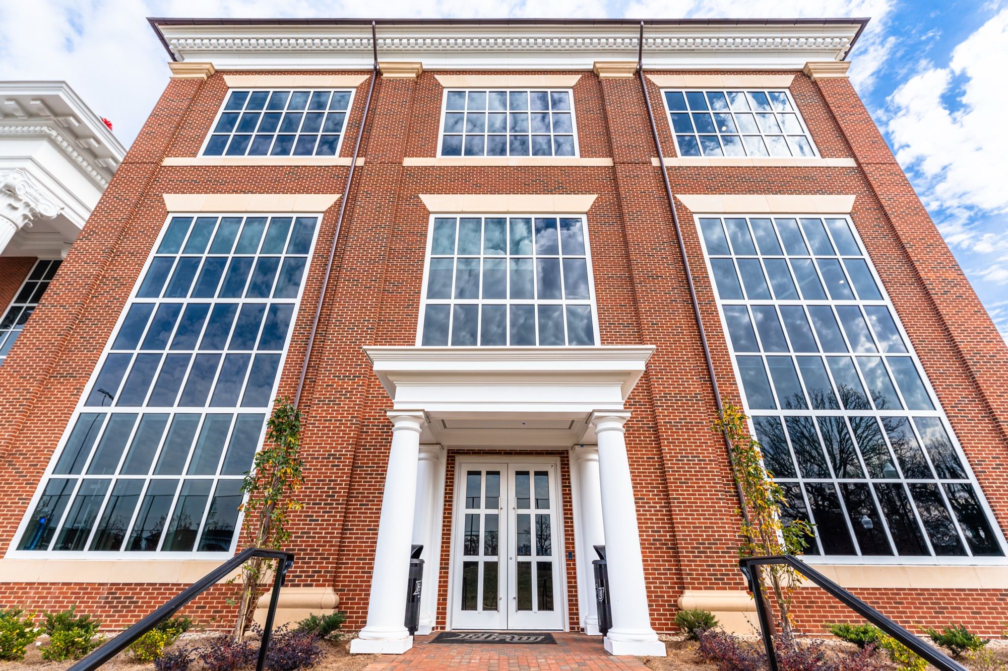 Side entry with tall aluminum windows on the brick facade