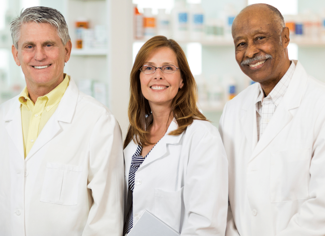 Pharmacist reading medication information on a tablet with an inset of a doctor writing a prescription.