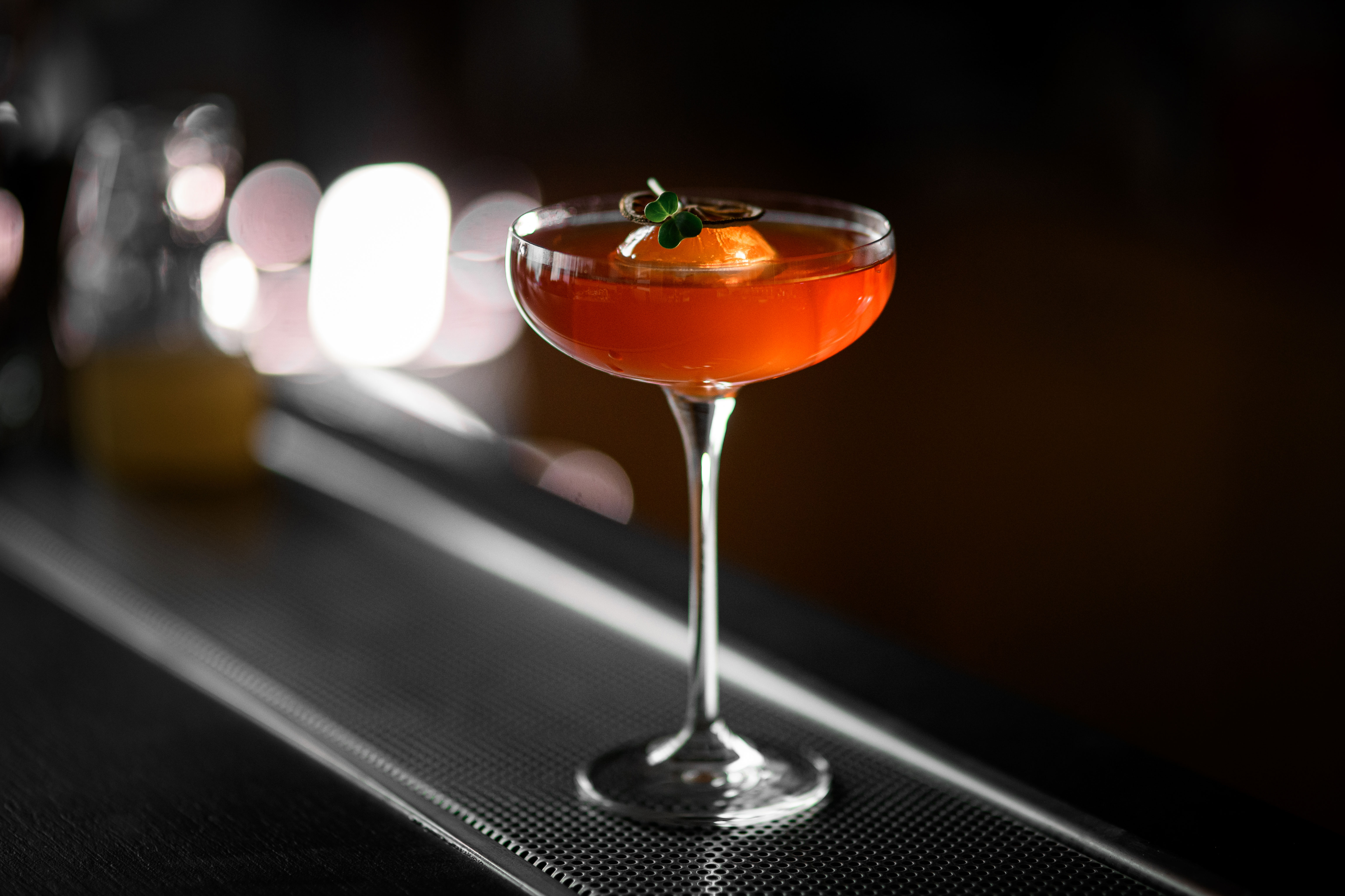 A cocktail in a glass on a bar ledge