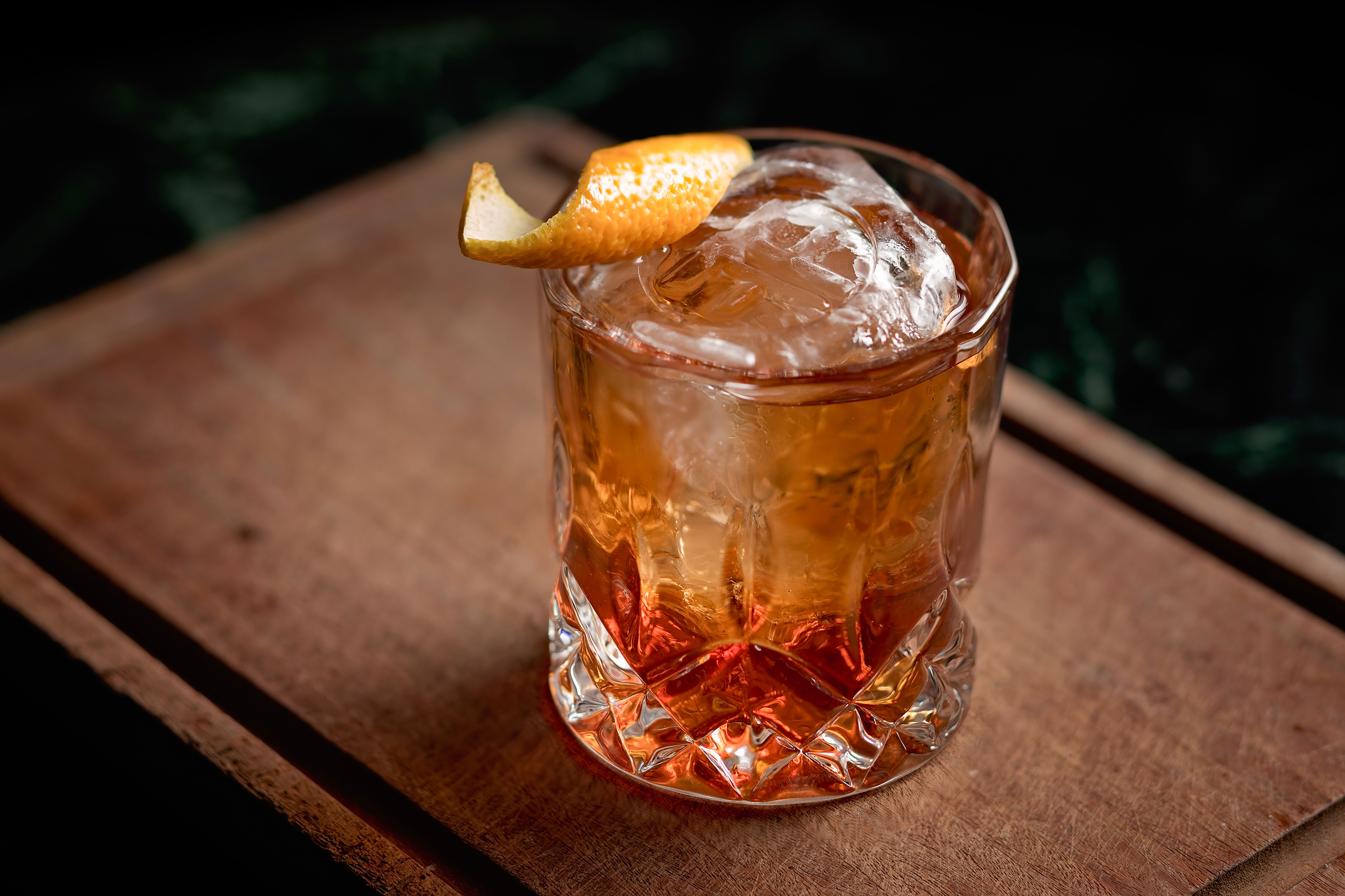A cocktail in a glass sitting on a bar