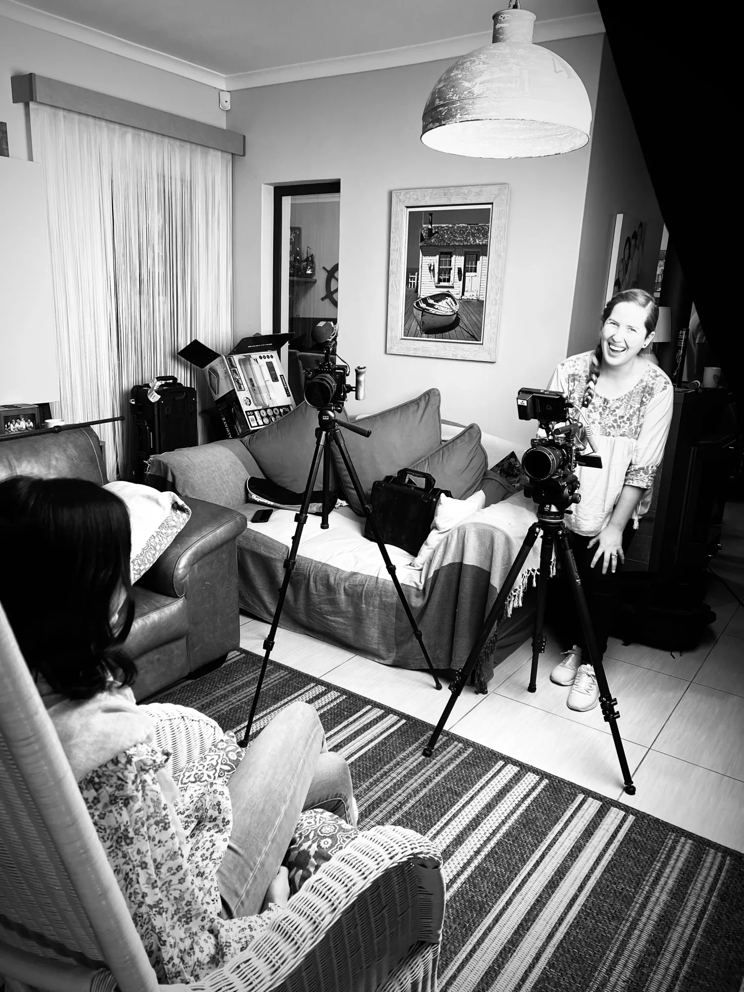 Two cameras on tripods set up to film a documentary interview in a family living room