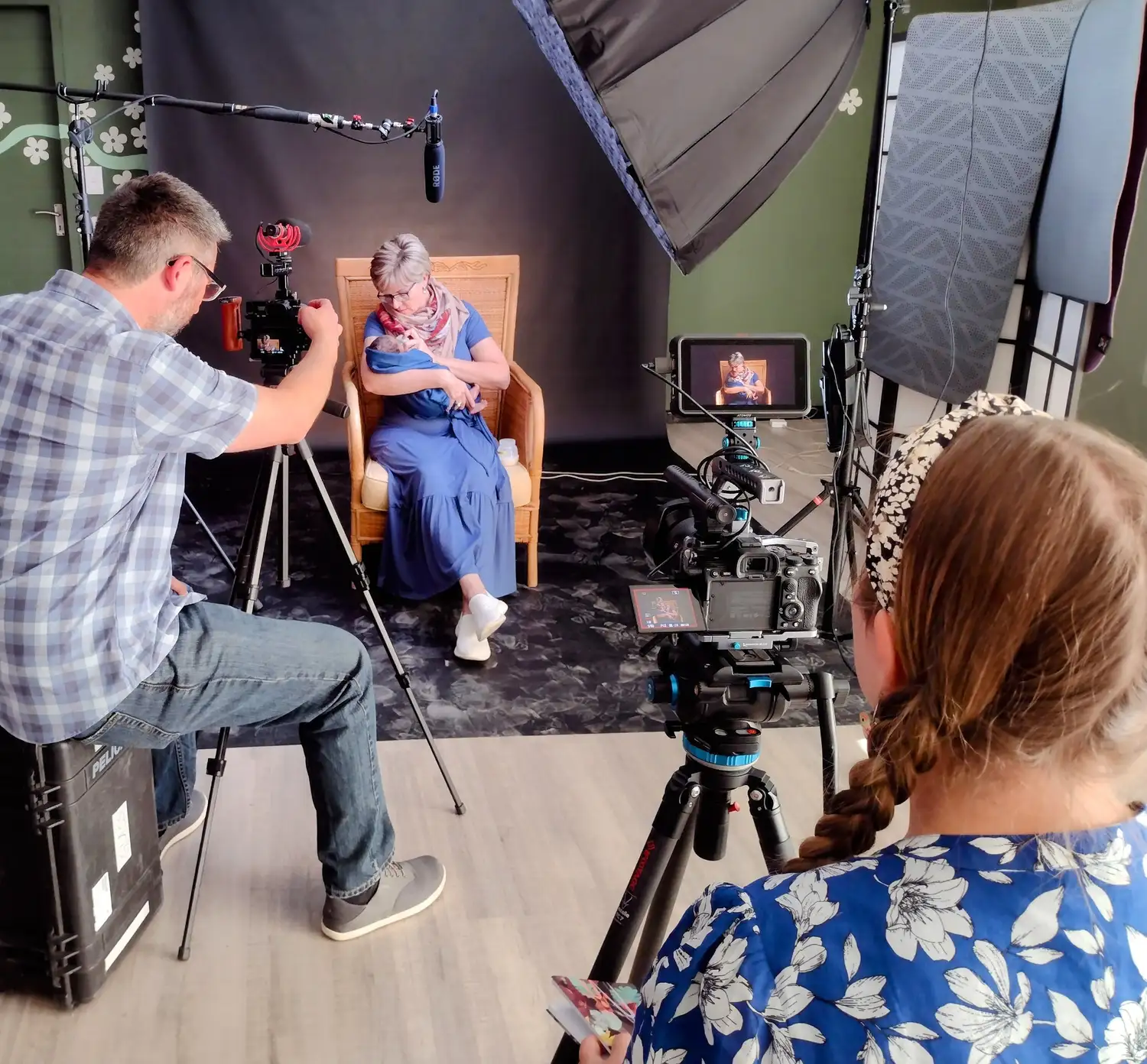 Crew filming a seated interview with studio lights, boom microphone and cameras