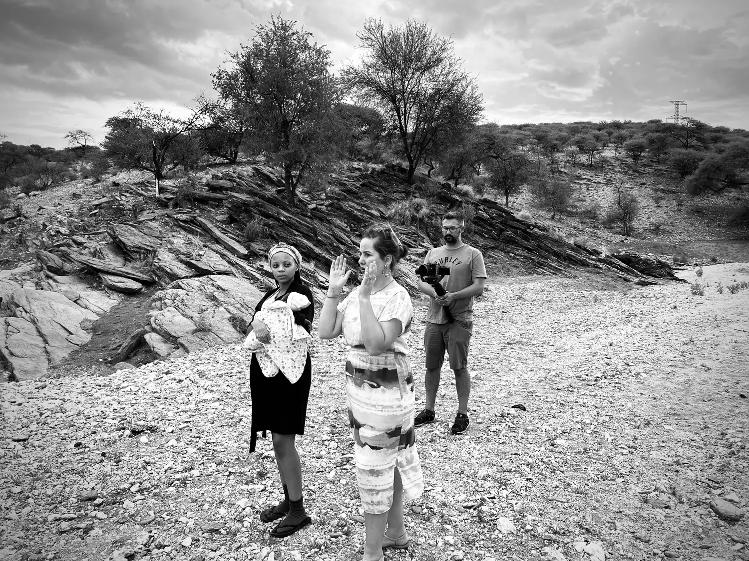 Director and crew filming a scene on rocky terrain in the Namibian countryside