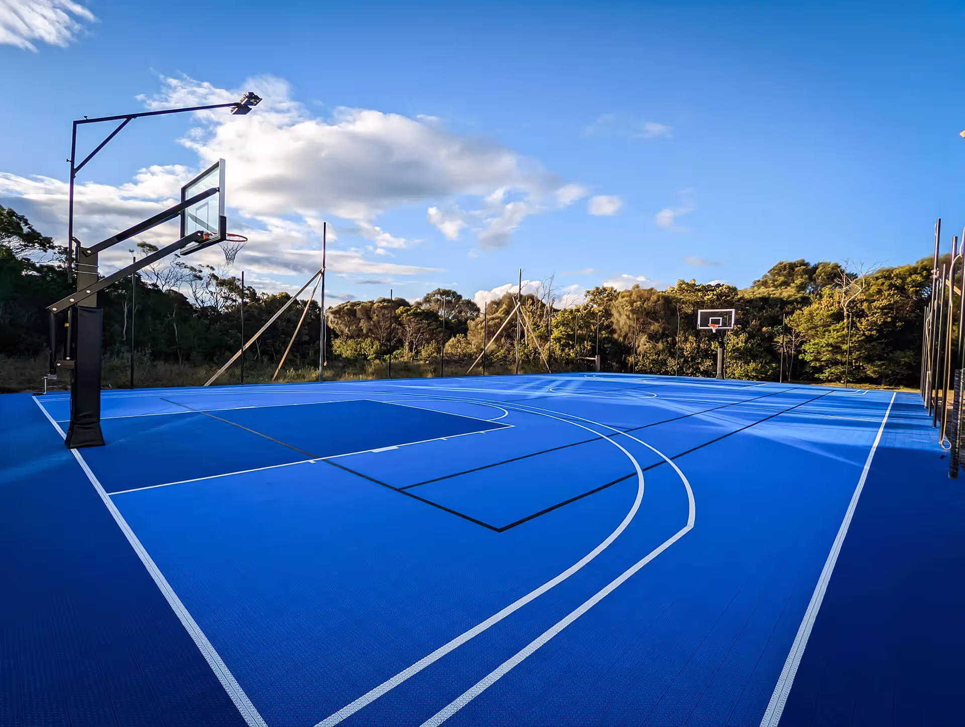 An outdoor basketball court with a basketball hoop.