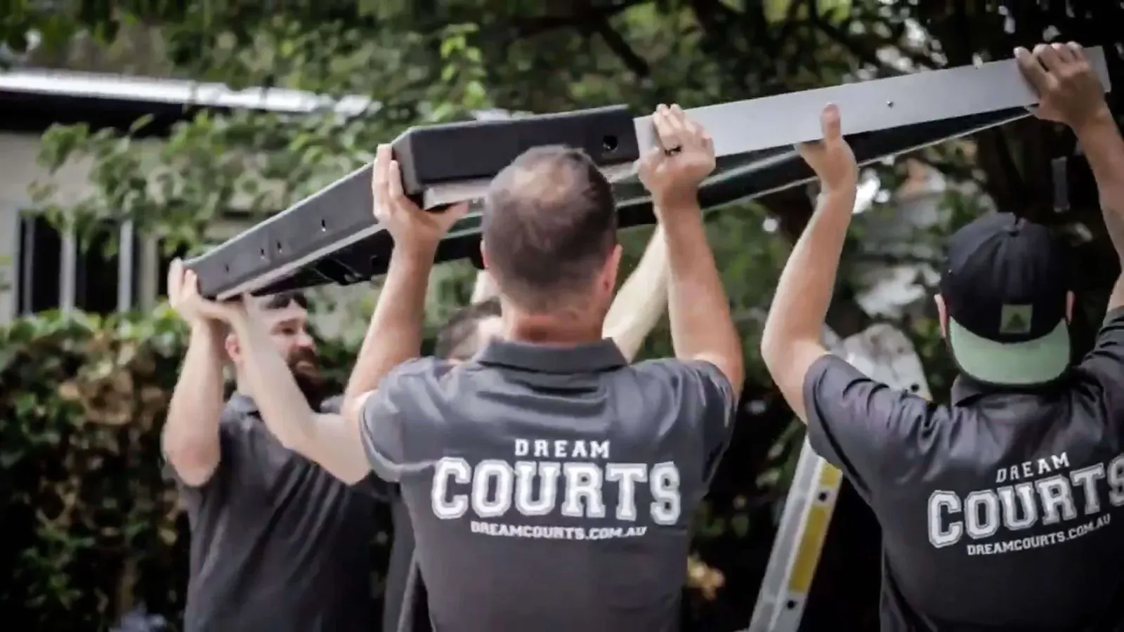A group of men installing a basketball ring