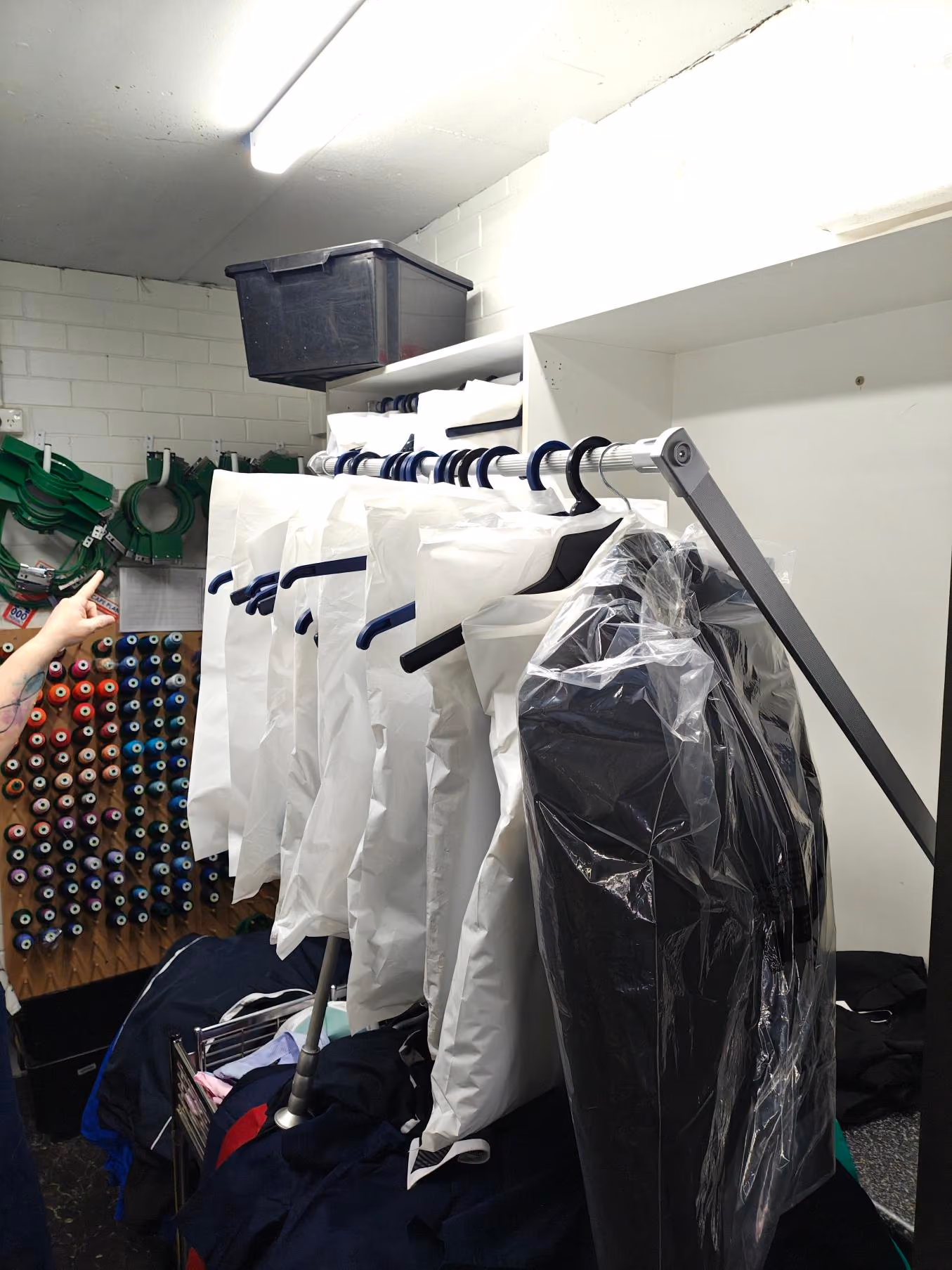 A range of monogramming orders fill a rack, ready for pick up